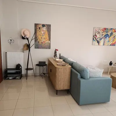 a living room with a blue couch and a table at Del's Apartment in Chania Town