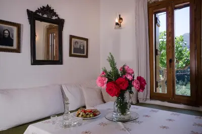 a living room with a table with a vase of flowers at Kallimento-Dimitra in Kissamos