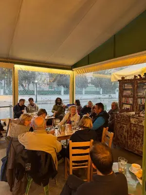 a group of people sitting at tables in a restaurant at WHITE MOUNTAINS Nature Home in Arménoi