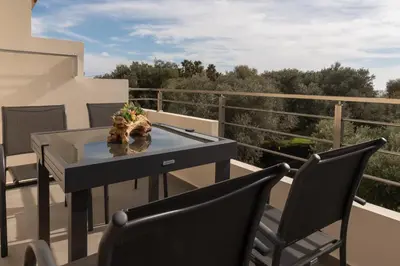 a balcony with a table and two chairs on a roof at Diktamo apartment, Palaiochora in Palaiochóra