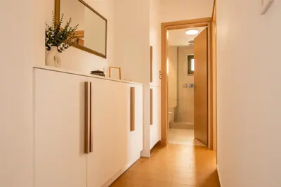 a hallway with white cabinets and a mirror at Diktamo apartment, Palaiochora in Palaiochóra