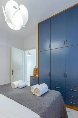 a bedroom with blue cabinets and two towels on a bed at Urban Living City Apartment in Chania Town