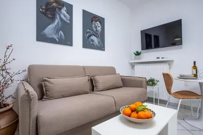a living room with a couch and a bowl of fruit on a table at Urban Living City Apartment in Chania Town