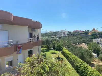two people standing on a balcony of a building at Nea Kydonia suites and studios in Daratso