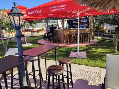 a restaurant with tables and chairs and a red umbrella at Nea Kydonia suites and studios in Daratso