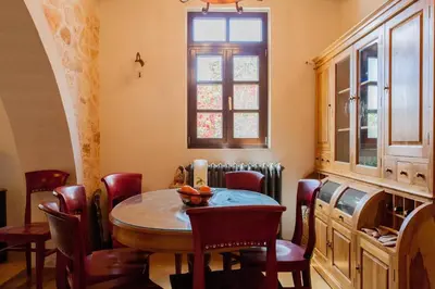 a dining room with a table and chairs and a window at Luxurious Venetian 3 FLOOR HOUSE in the old port in Chania Town