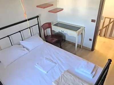 a bedroom with a bed and a desk and a chair at Luxurious Venetian 3 FLOOR HOUSE in the old port in Chania Town