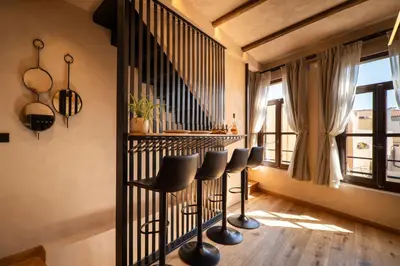 a bar with stools in a room with a window at Mimosa Veneziano - Sauna - Old Town Chania in Chania Town
