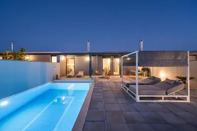 a house with a swimming pool at night at Natura Hill Villa II Sunset View in Kounoupidhianá