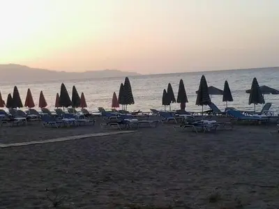 a group of chairs and umbrellas on a beach at Gradma Katina in Plataniás