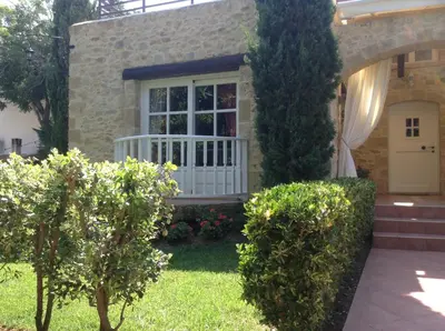 a house with a white door and some bushes at Rock House's Villa Melody in Plataniás