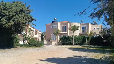 a large house with palm trees in front of it at Relax Holiday Villa in Maleme