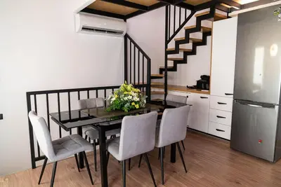 a dining room with a table and chairs and a staircase at Sappho 3-bedroom House in Daratso