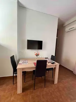 a dining room table with chairs and a television on a wall at Haris home 1 in Chania Town