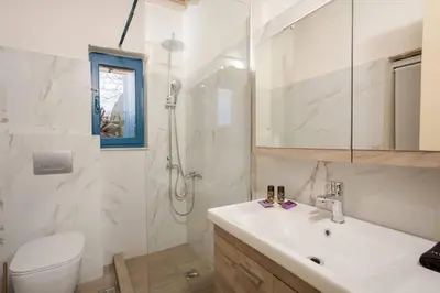 a bathroom with a sink and a toilet and a shower at Halases Panorama Villa pvt pool in Alikampos