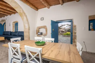 a dining room with a wooden table and chairs at Halases Panorama Villa pvt pool in Alikampos