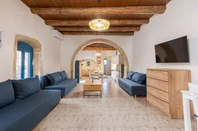 a living room with blue couches and a tv at Halases Panorama Villa pvt pool in Alikampos