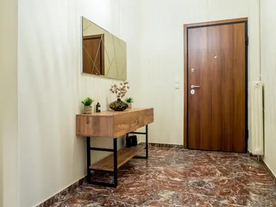 a hallway with a mirror and a wooden door at Atenà Urban Living in Chania Town