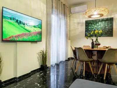 a living room with a television on a wall at Atenà Urban Living in Chania Town