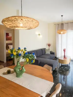 a living room with a couch and a table with flowers at Atenà Urban Living in Chania Town