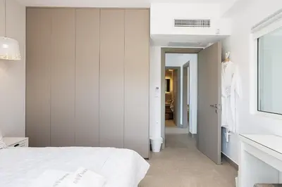 a bedroom with a white bed and a hallway at Feli Living in Spiliá