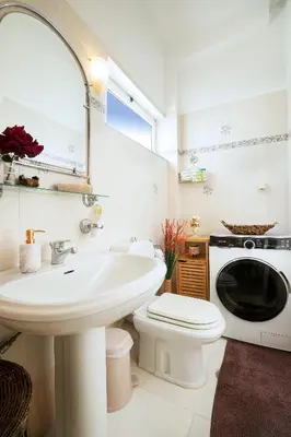 a bathroom with a sink and a washing machine at Casa BI LA in Galatás