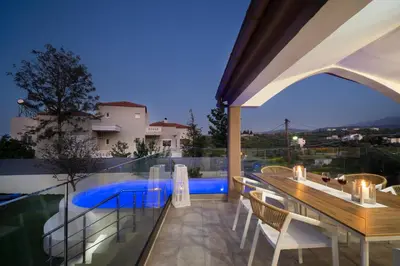 a balcony with a table and chairs and a pool at Casa BI LA in Galatás