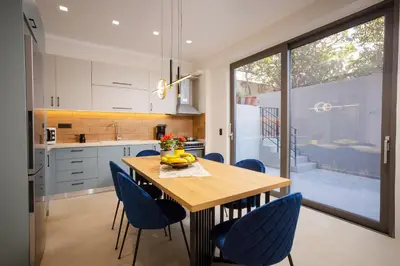 a kitchen with a wooden table and blue chairs at Polixenys home in Daratso