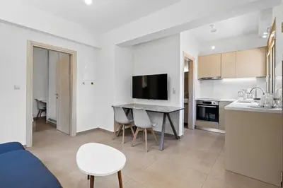 a kitchen and living room with a table and chairs at AURA - Deluxe Apartment in Chania Town