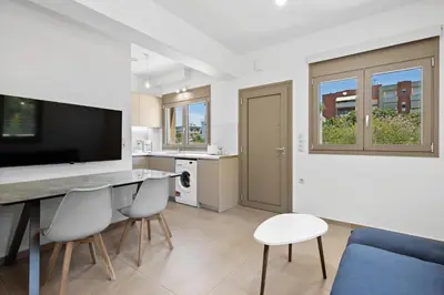 a kitchen and living room with a table and chairs at AURA - Deluxe Apartment in Chania Town
