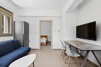 a living room with a blue couch and a table at AURA - Deluxe Apartment in Chania Town