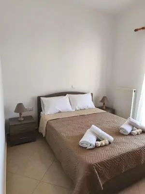 a bedroom with a bed with two towels on it at Van Gogh & Monet apartments in Maleme