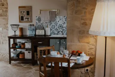 a kitchen with a small table and a table with a lamp at Ewa's Cretan Vintage Houses in Kharkhalianá