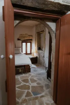 a bedroom with a bed in a room with a stone floor at Ewa's Cretan Vintage Houses in Kharkhalianá