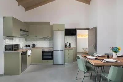 a kitchen with a table and a dining room at Villa Lakioto in Dhémbla