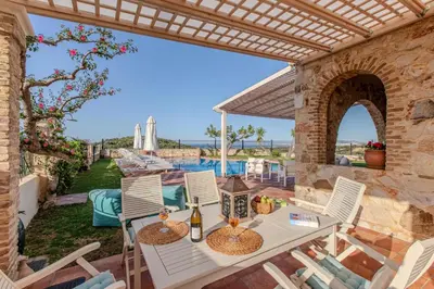a patio with a table and chairs and a pool at Villa Trouli by Vintage Travel in Metókhi