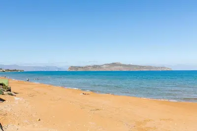 a beach with people swimming in the water at Villa Trouli by Vintage Travel in Metókhi