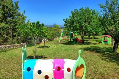 a playground with a play equipment in a park at Villa Halepi by PosarelliVillas in Gavalochori