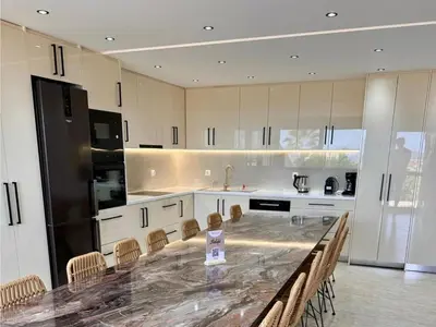 a large kitchen with a large marble table and chairs at Villa Halepi by PosarelliVillas in Gavalochori