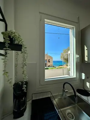 a kitchen with a window with a view of the ocean at Breezy Sea View Appartment in Chania Town