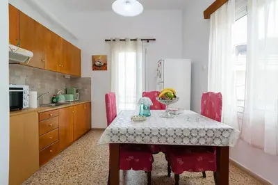 a kitchen with a table with red chairs and a kitchen sidx sidx sidx at Chania Vintage Escape - sea view Gem by old port in Chania Town