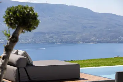 a couch and a tree on a deck with a view of a lake at Etheria Elli Villa, Retreat to Ethereal Luxury and Wellness by etouri in CHQ