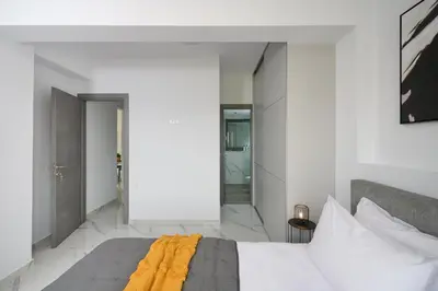 a bedroom with white walls and a bed with a yellow blanket at Galanakis luxury villa in Chania Town