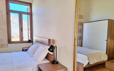 a bedroom with two beds and a mirror at Casa Kadanoleon old town with private terrace in Chania Town