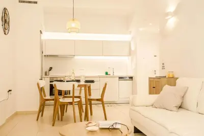 a kitchen and living room with a table and a couch at Be Crete - Miramare apartment in Chania Town