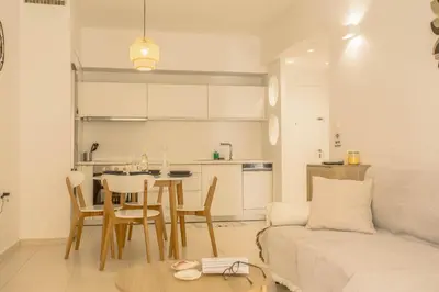 a living room with a couch and a table and a kitchen at Be Crete - Miramare apartment in Chania Town