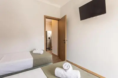 a bedroom with a bed and a tv on the wall at Zen City Apartment in Chania Town