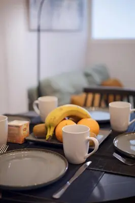 a table with plates and cups and fruit on it at Zen City Apartment in Chania Town