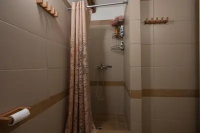 a shower with a shower curtain in a bathroom at Telesilla's home in Apothíkai