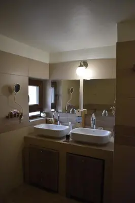 a bathroom with two sinks and a large mirror at Telesilla's home in Apothíkai